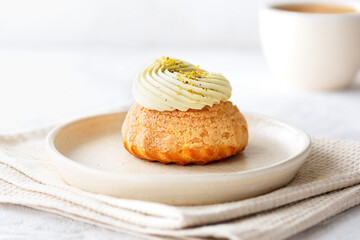 Obraz na płótnie Canvas Choux cake with pistachio cream, French dessert shu with a cup of coffee.