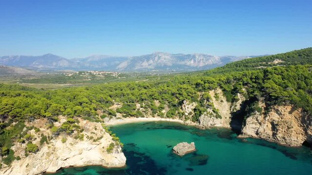 The fine sandy beach of Alonaki Fanariou with its green rocky cliffs, in Europe, in Greece, in Epirus, towards Igoumenitsa, on the edge of the Ionian Sea, in summer, on a sunny day.&nbsp;