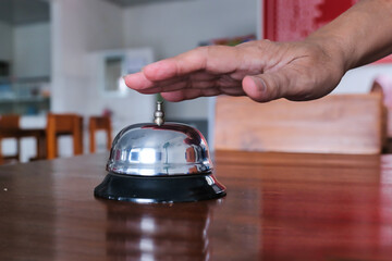 A silver service bell on a wooden desk to call for assistance