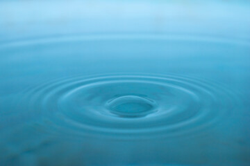 Water drop. Close-up circle ripples on water surface. Clear Water drop with circular waves