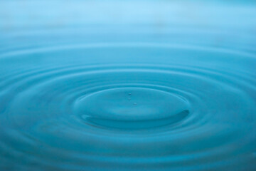 Water drop. Close-up circle ripples on water surface. Clear Water drop with circular waves