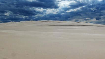 Fototapeta na wymiar Sandy Desert and Dark Storm Clouds