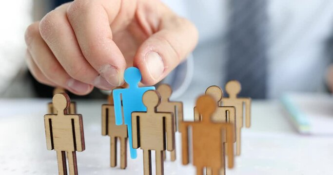 Person puts special person in the middle of identical wooden figures. Building a successful career concept