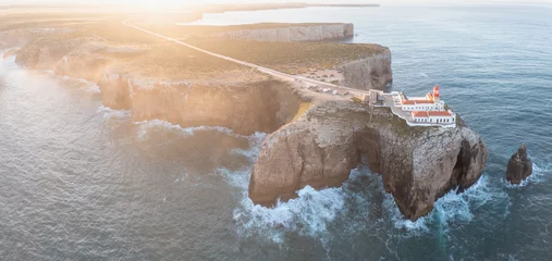 Photo sur Plexiglas Beige Atop the rugged cliffs of Cabo de São Vicente, Farol do Cabo de São Vicente lighthouse, panoramic view of the Atlantic Ocean, making it a visit place on vacations in the Algarve region. Aerial view.