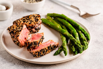 Tuna steak fried in sesame seeds served with asparagus.