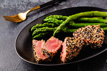 Tuna steak fried in sesame seeds served with asparagus.