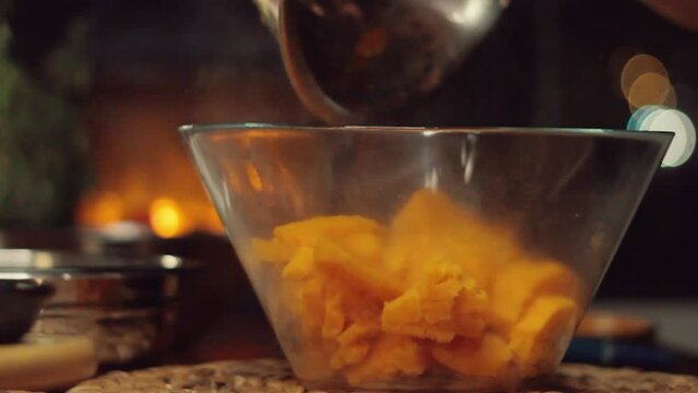 Preparing sweet potato salad. Sweet potatoes are mashed and greens are added.