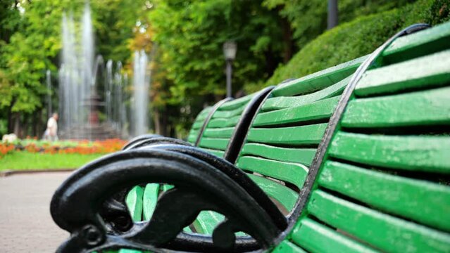 View of the Stefan cel Mare Central Park in Chisinau, Moldova. Green benches with working fountain on the background, walking people and greenery