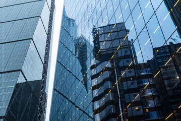 Modern abstract reflections in glass fronted commercial office buildings in the financial district of the British capital London. - obrazy, fototapety, plakaty