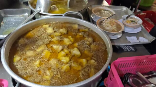 Traditional Indonesian Soto Daging (Beef Soup) Being Ladled into Serving Bowls in a Restaurant Kitchen in Indonesia