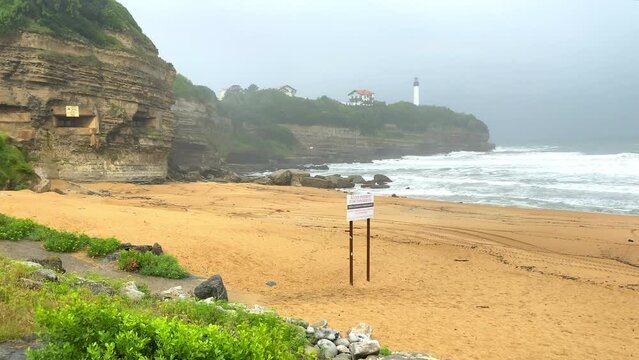 Pointe Saint-Martin and lighthouse of Biarritz seen from the Chambre d'amour beach in Anglet, France a bad weather day
