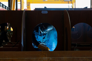 Welder welding in a shipyard steel blocks