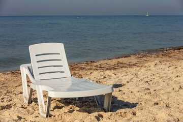 white plastic lounger on the background of the sea