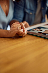 Focus on the married people holding hands while watching a photo album.