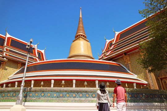 Couple Impressed by a 43 Meters High Gilded Pagoda and the Iconic Circular Gallery of Wat Ratchabophit Buddhist Temple, Bangkok, Thailand