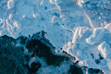 Top view of the icy seashore. Winter aerial photograph of ice floes on the sea coast. Amazing...