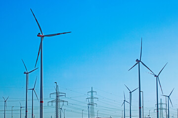 windmills with power plants against the blue sky. Economic crisis