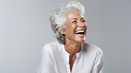 A closeup photo of a elderly senior model woman laughing and smiling with clean teeth on white background - obrazy, fototapety, plakaty