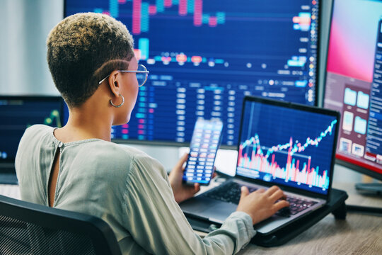 Business woman, phone and laptop on stock market in fintech, trading or online finance at office. Female person, broker or financial advisor on mobile smartphone or computer for profit, app or growth