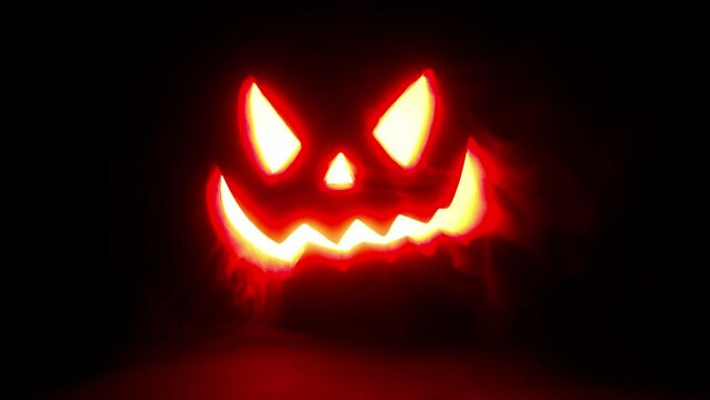 Glowing jack o lantern face on black background, smoke and haze, 4k high resolution halloween asset.