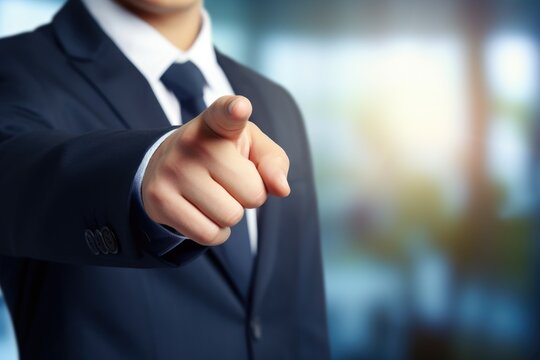 Businessman pointing finger to you on blurred background