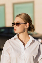 Portrait of a young and attractive Caucasian woman in casual clothes and sunglasses while walking around the city. The concept of fashion, style, youth and lifestyle