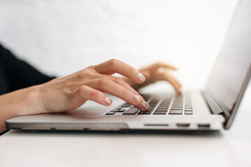 Close up woman's hands typing on laptop keyboard at home office. Businesswoman or student girl using pc for online internet marketing, freelance, work from home, education online, distance studying