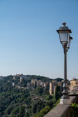 Walking in Castel Gandolfo, summer residence of pope, view on green Alban hills overlooking volcanic crater lake Albano, Castelli Romani, Italy in summer
