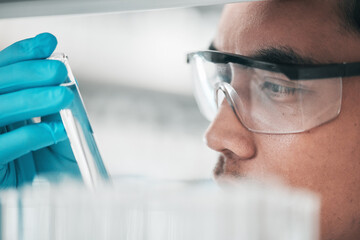 Science, research and man looking at test tube in laboratory, solution for vaccine or medical...