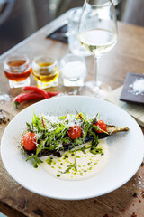 Vegan warm asparagus-broccoli salad with dill aioli, vegan cheese. Delicious healthy vegeterian food served for lunch on a table in modern gourmet cuisine restaurant - 648105655
