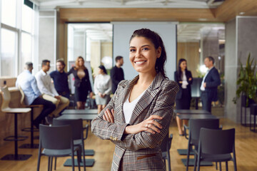 Portrait of successful young business woman looking at camera with confident expression. Female...