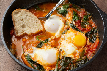 Shakshuka served in cast iron Frying Pan. Eggs in Spicy Tomato Pepper Sauce