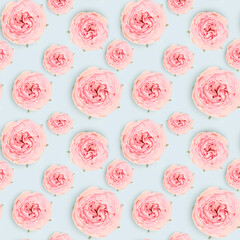 Seamless pattern made of pink rose flower on a blue background. Floral creative texture.