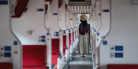 Fototapeta premium Back view of asian woman young backpacker stand interior of the train looking at the map for tourism. concept transport lifestyle active journey and travel adventure