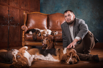 A man in an expensive suit with purebred basset dogs in an expensive stylish interior. A breeder...