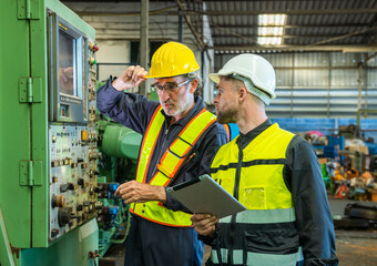 Two professional engineer worker technician assistant in helmet inspection check old machine construction factory with colleague manager. check old machinery production construction operating