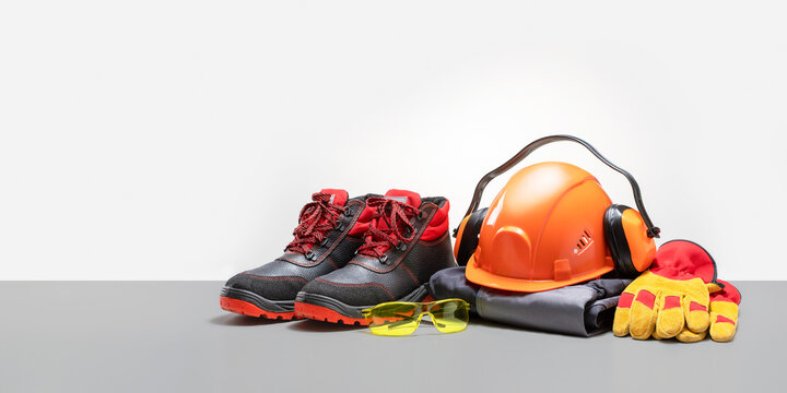  Industrial protective gear on the table, grey color background. Safety equipment. Banner with copy space.