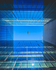 Reflective Futuristic Architecture with a Blue Hue and a Lone Individual.The plane passes right through the center of the building