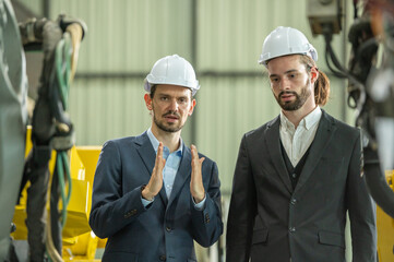 Group partner engineer assistant in helmet inspection check heavy machine construction installation in industrial metal roof roll sheet factory with colleague manager. partnership operation factory