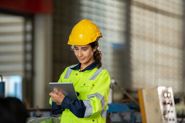 young woman engineer in uniform inspection warehouse and check control heavy machine construction installation in industrial factory. technician worker check for repair maintenance operation system
