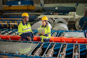 Factory apprenticeship. Man mentor teaching Female employees trainee operating machine looking monitors and check Production process machinery. foreman explaining woman engineer control machine .