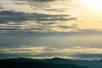 Soft golden light with sky clouds and sunrise in the morning, fog cover the jungle hill and village in northern of Thailand.