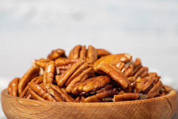 Brazil nut in wood bowl. Brazilian or amazon walnut on white wood background. Close up