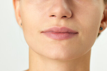 Cropped image of female face, nose, lips and chin isolated on white background. Plastic surgery,...