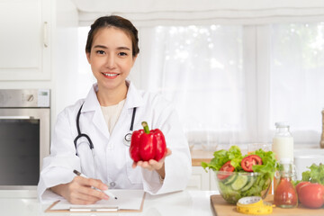 Nutritionist desk with healthy fruits, juice and measuring tape. Dietitian working on diet plan at...