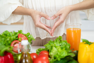 Female make shape of heart with her hands. Light summer breakfast with organic vegetable, fruits....