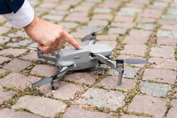 Durch Fingerdruck wird Drohne in Betrieb genommen - obrazy, fototapety, plakaty