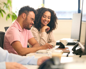 Woman Working In Office Based Business Training Man With Down Syndrome Using Computer
