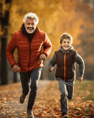 Active senior man jogging with his grandson in autumn park.