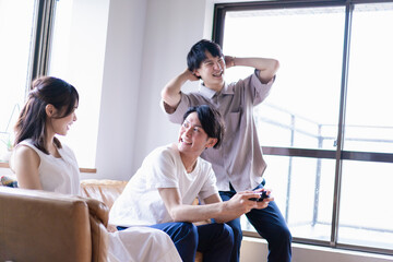 家でテレビゲームをする若い男女